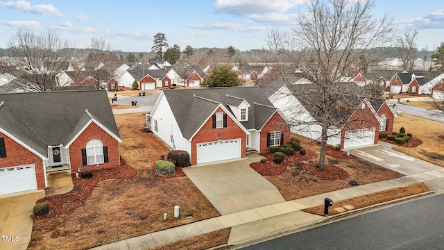 traditional home with a garage, brick siding, driveway, roof with shingles, and a residential view