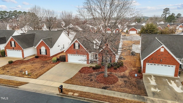 traditional-style house featuring a garage, a residential view, and brick siding