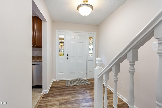 entrance foyer featuring baseboards, stairway, and light wood finished floors