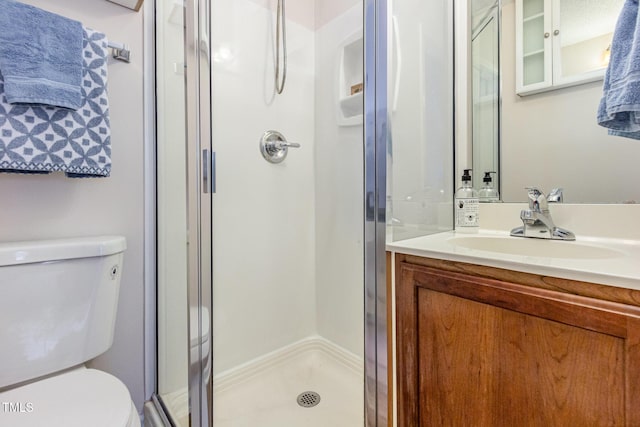 bathroom featuring a stall shower, vanity, and toilet