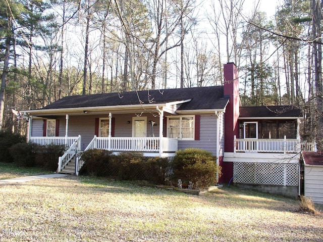 single story home with a sunroom, covered porch, and a front lawn