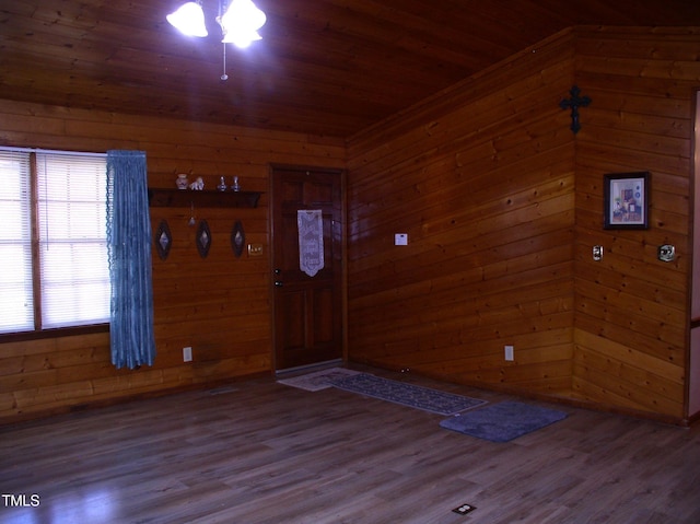 foyer entrance featuring hardwood / wood-style floors, wood ceiling, and wood walls