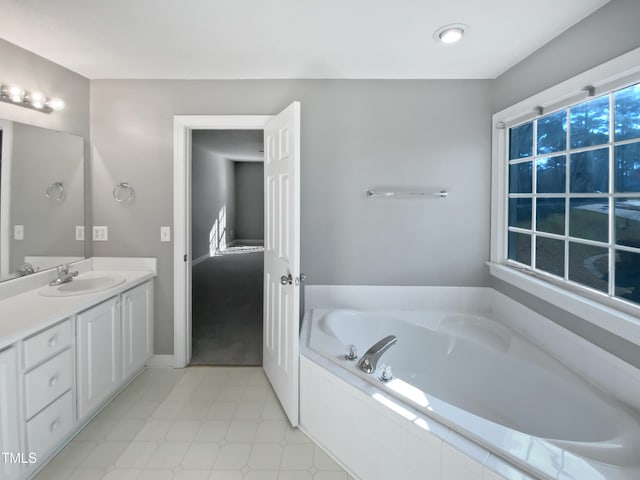 bathroom with vanity and tiled bath