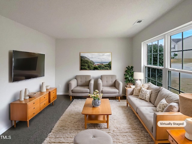 living room with dark carpet and a textured ceiling