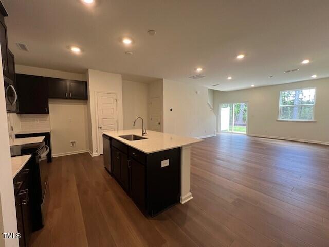 144 Parker Ln, Mebane, NC 27302 - kitchen featuring baseboards, recessed lighting, light countertops, dark wood-type flooring, and a sink