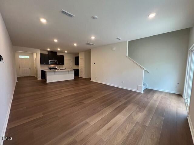 144 Parker Ln, Mebane, NC 27302 - unfurnished living room featuring stairway, visible vents, baseboards, and dark wood finished floors
