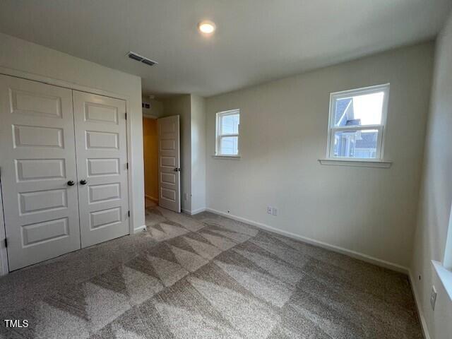 144 Parker Ln, Mebane, NC 27302 - unfurnished bedroom with visible vents, a closet, baseboards, and carpet floors