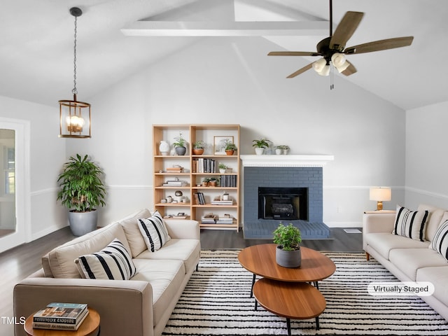 living room featuring dark wood-type flooring, ceiling fan, a fireplace, and high vaulted ceiling