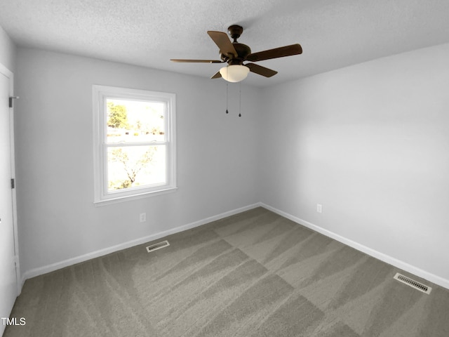 empty room with ceiling fan, carpet flooring, and a textured ceiling