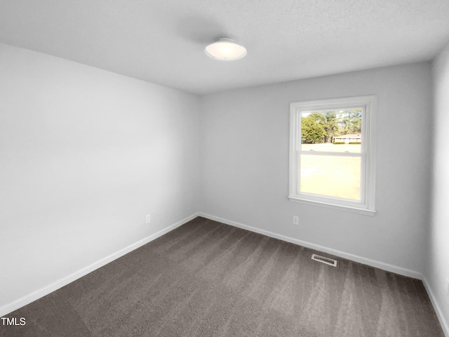 carpeted spare room with a textured ceiling