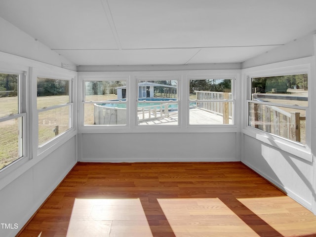 unfurnished sunroom featuring lofted ceiling and a wealth of natural light