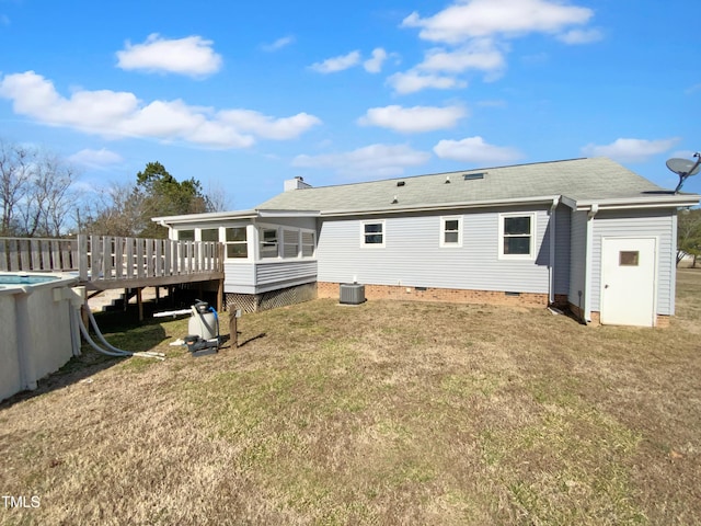 rear view of house with a wooden deck, a sunroom, a yard, and cooling unit