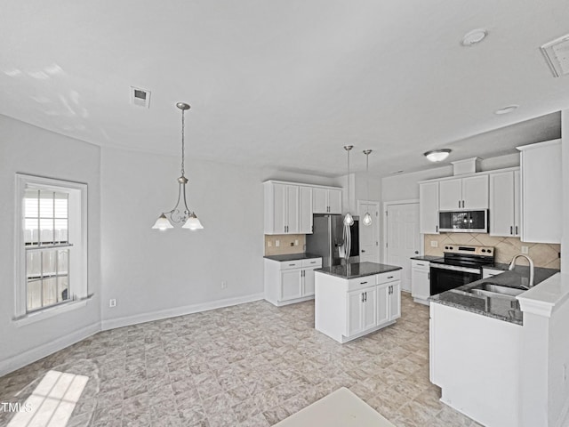 kitchen featuring stainless steel appliances, a kitchen island, sink, and pendant lighting