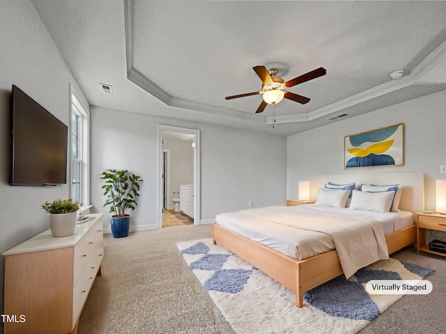 carpeted bedroom featuring ceiling fan, connected bathroom, and a raised ceiling