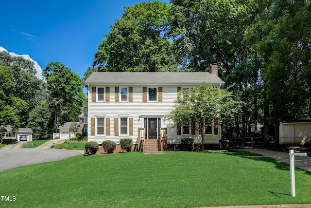 colonial house with a garage and a front lawn