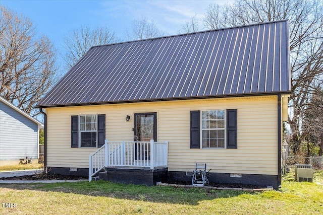 view of front of property with crawl space, central AC unit, metal roof, and a front yard