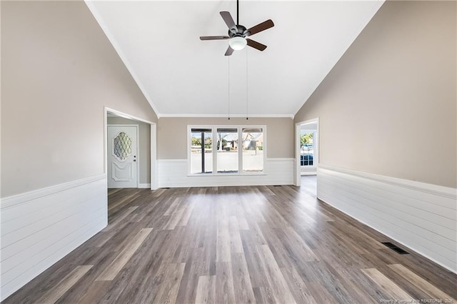 unfurnished living room featuring dark wood-type flooring, ceiling fan, crown molding, and high vaulted ceiling