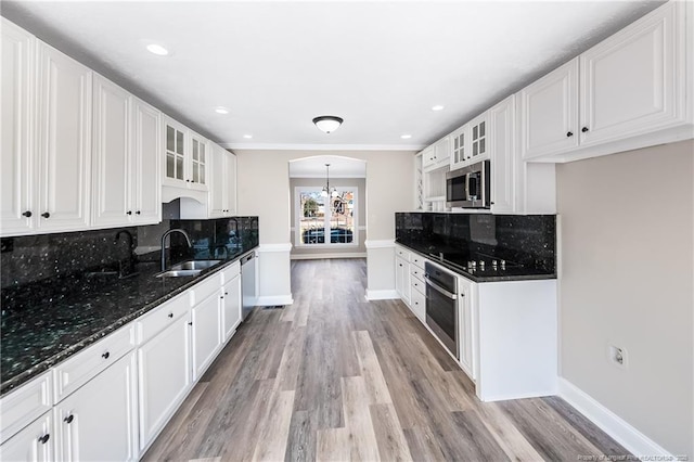 kitchen with sink, an inviting chandelier, appliances with stainless steel finishes, dark stone counters, and white cabinets