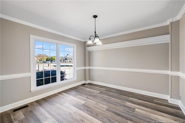 unfurnished dining area with ornamental molding, dark hardwood / wood-style floors, and a chandelier