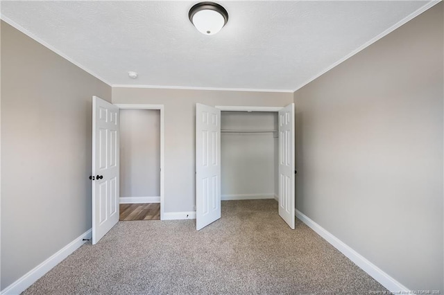 unfurnished bedroom featuring crown molding, a closet, carpet, and a textured ceiling