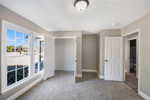 unfurnished bedroom with carpet flooring, a closet, and a textured ceiling