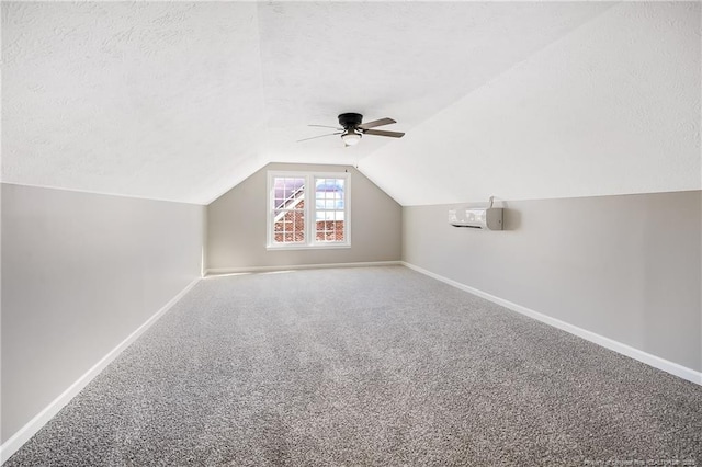 bonus room featuring lofted ceiling, ceiling fan, carpet floors, and a textured ceiling