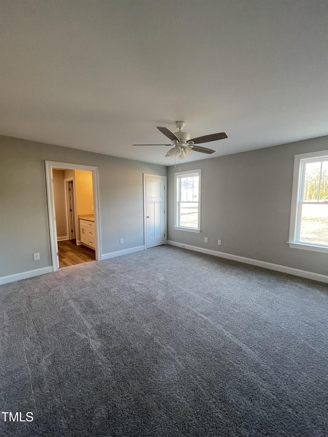 unfurnished bedroom featuring ceiling fan, carpet flooring, and ensuite bath