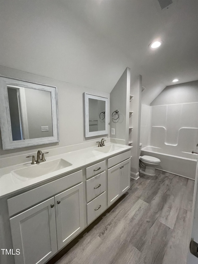 full bathroom with vanity, hardwood / wood-style floors, shower / tub combination, and toilet