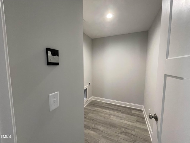 clothes washing area featuring electric dryer hookup and light hardwood / wood-style floors