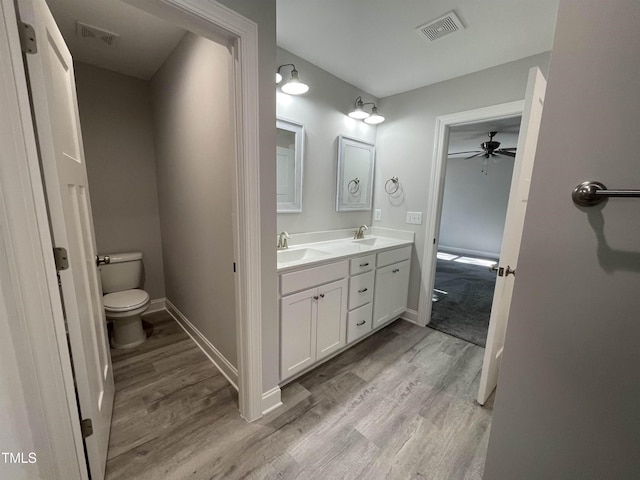 bathroom featuring wood-type flooring, toilet, and vanity