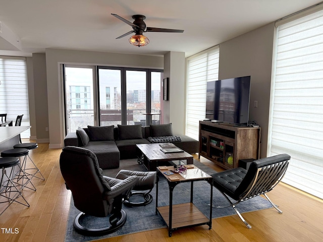 living room featuring ceiling fan and light hardwood / wood-style flooring