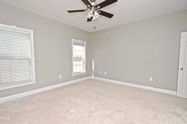 carpeted spare room featuring ceiling fan