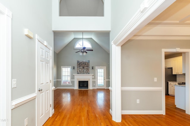 unfurnished living room with ceiling fan, high vaulted ceiling, and light hardwood / wood-style floors