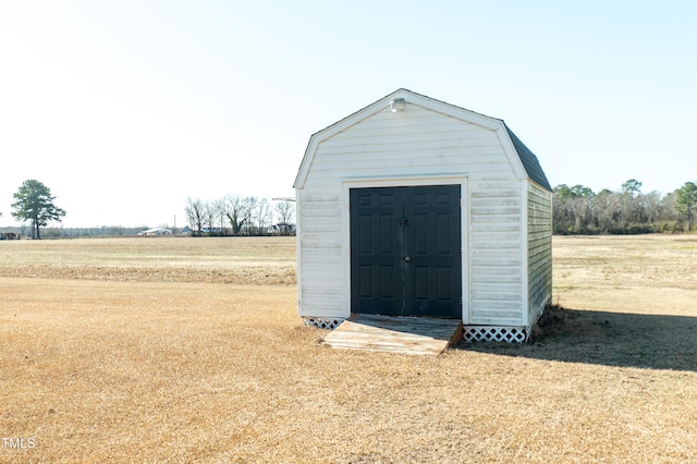 view of outbuilding featuring a yard and a rural view