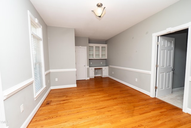 interior space featuring built in desk and light wood-type flooring