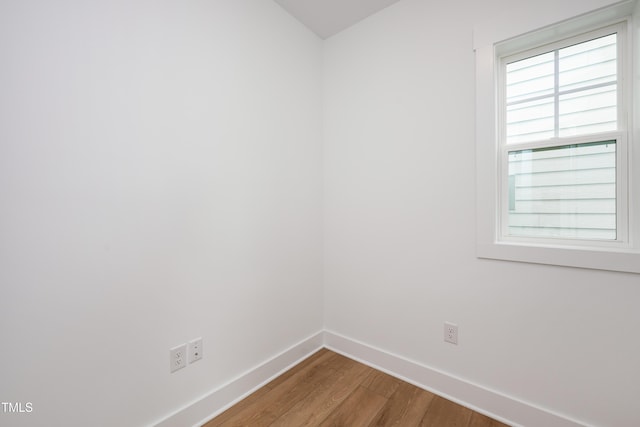 unfurnished room featuring baseboards and wood finished floors