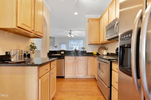 kitchen with sink, light brown cabinets, kitchen peninsula, and appliances with stainless steel finishes