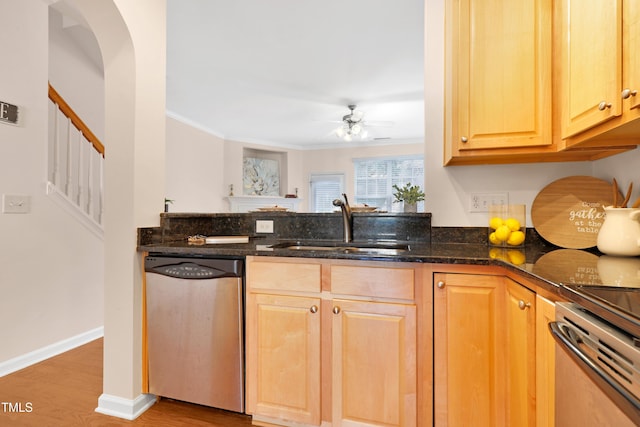 kitchen with ornamental molding, dark stone counters, dishwasher, and sink