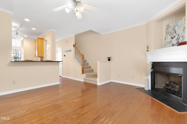 unfurnished living room featuring crown molding, ceiling fan, and wood-type flooring