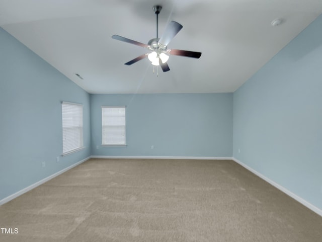 spare room with ceiling fan, lofted ceiling, and light carpet