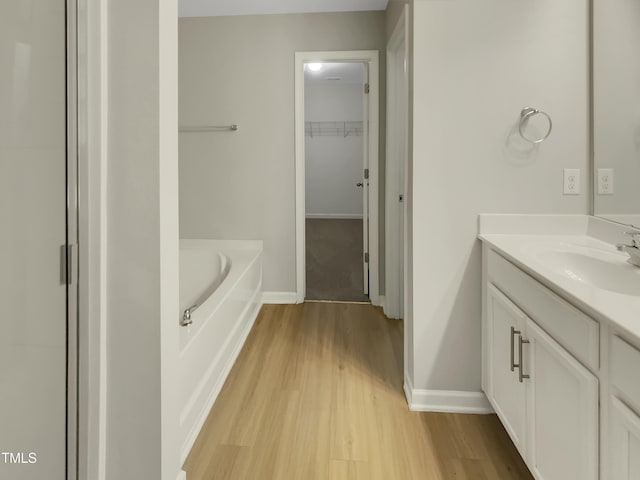 bathroom with vanity, a washtub, and hardwood / wood-style flooring