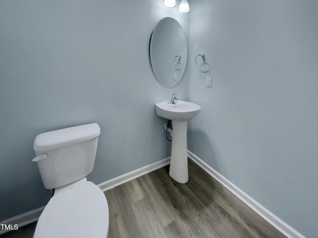 bathroom with toilet and hardwood / wood-style floors