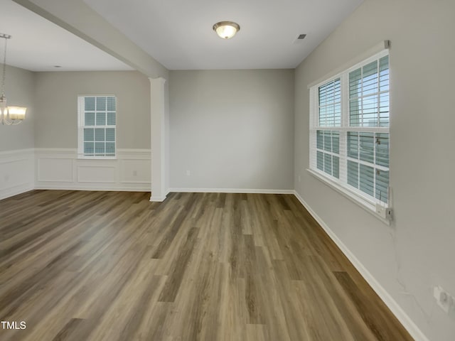 unfurnished room with hardwood / wood-style floors and a chandelier