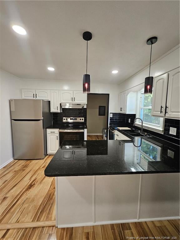 kitchen with appliances with stainless steel finishes, decorative light fixtures, sink, and white cabinets