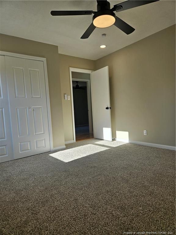 unfurnished bedroom featuring ceiling fan, a closet, and carpet