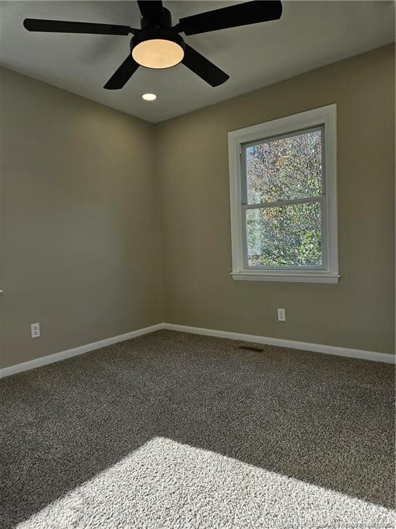 carpeted spare room featuring ceiling fan