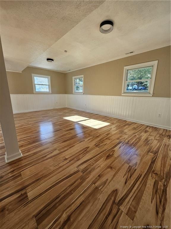 additional living space with wood-type flooring and a textured ceiling