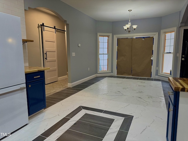 entrance foyer featuring a notable chandelier and a barn door