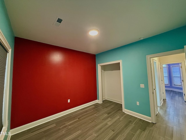 unfurnished bedroom with wood-type flooring and a closet