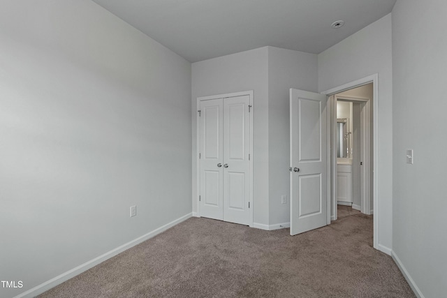 unfurnished bedroom with carpet flooring and a closet